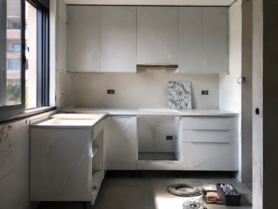 Cocina en montaje con muebles protegidos e instalaciones pendientes de rematar